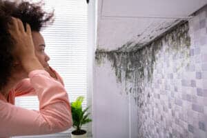 Femme regardant la moisissure sur le mur