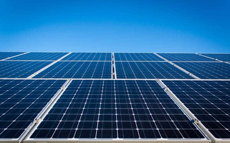 Solar panels array under a clear blue sky, capturing sunlight to generate renewable energy.